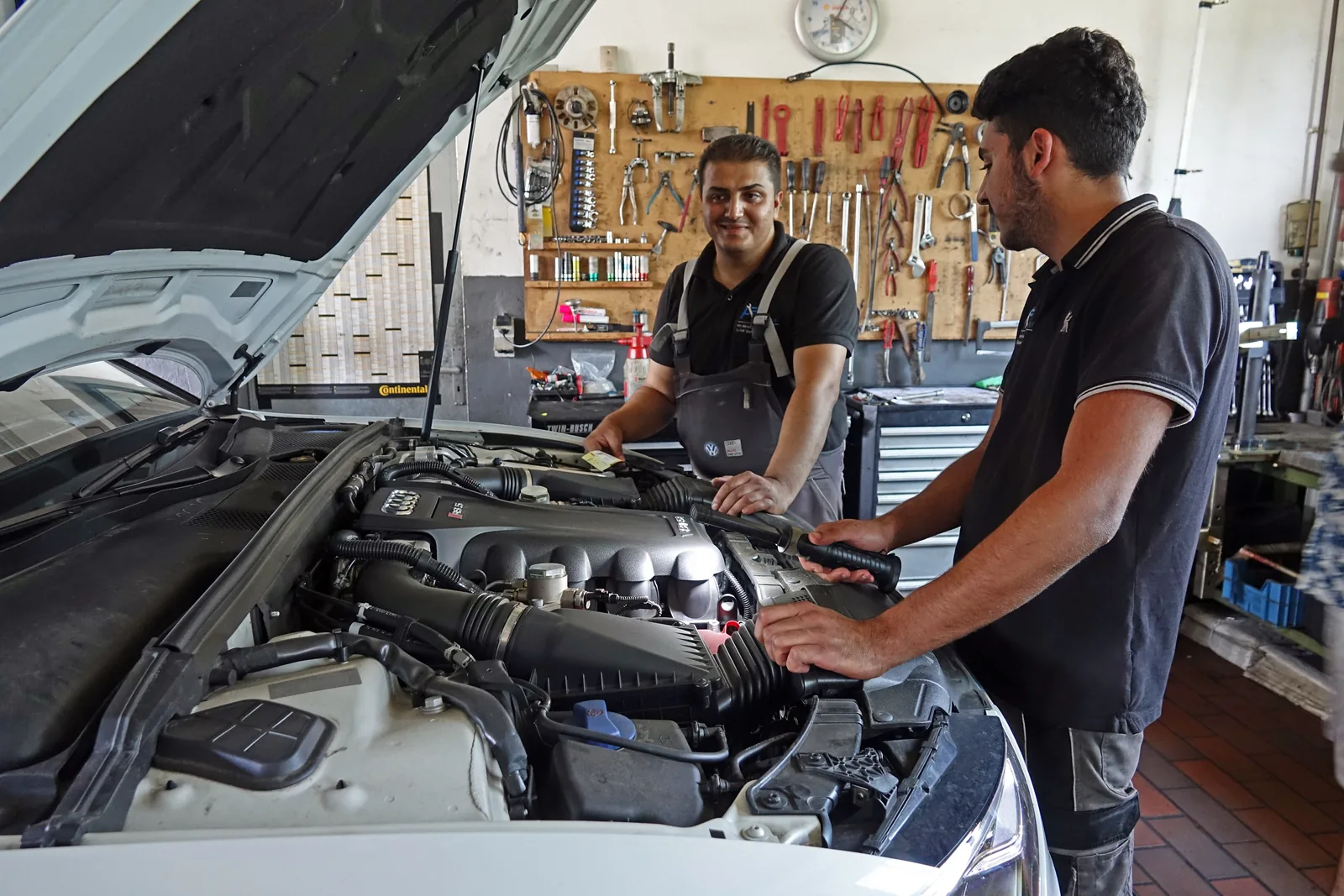 Zwei autoFUNK-Mitarbeiter prüfen gemeinsam ein Fahrzeug in der Werkstatt
